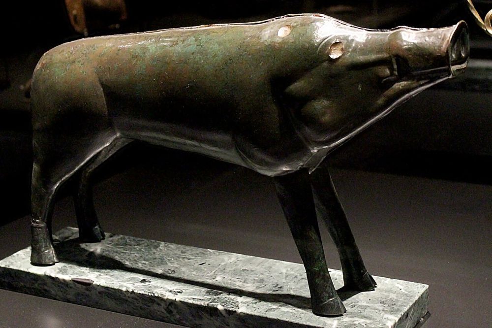 Sanglier de bronze stylisé aux lignes épurées, présenté sur un socle de musée